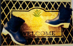 black clog boots on pineapple doormat